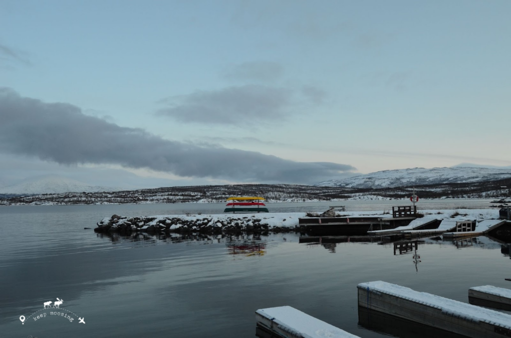 Tornetrask lake near Abisko. Image representing the pier and three colored canoes on the lakeside.