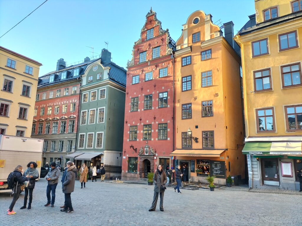 Claudia in Gamla Stan, the historical centre of Stockholm. Behind her colorful houses.