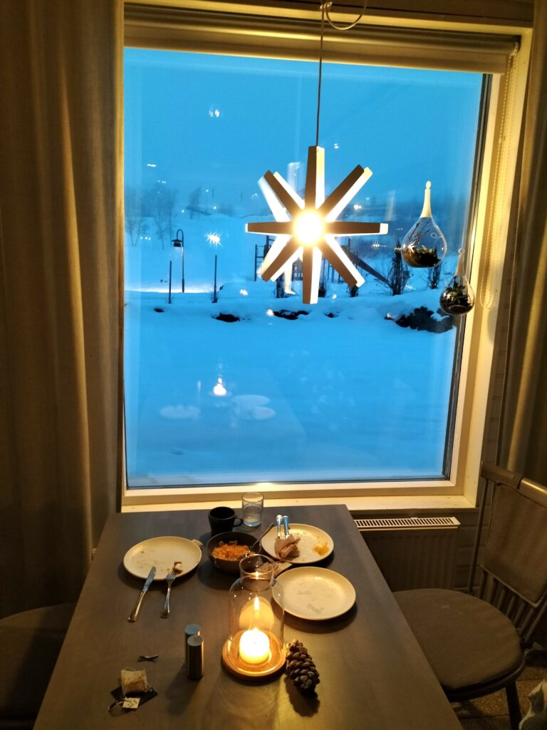 Breackfast inside Camp Ripan. Our table in the foreground with three dishes in front of a big window. Outside the window a lot of snow.