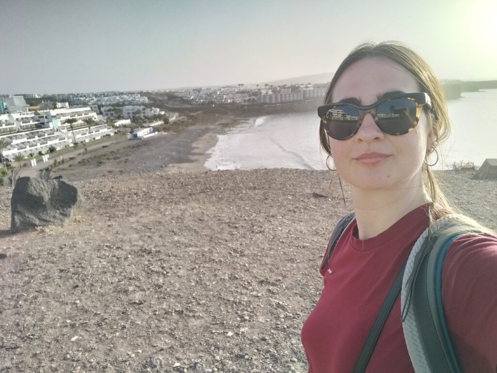 Claudia in the foreground, in the background the white houses of Playa Blanca and the sea.