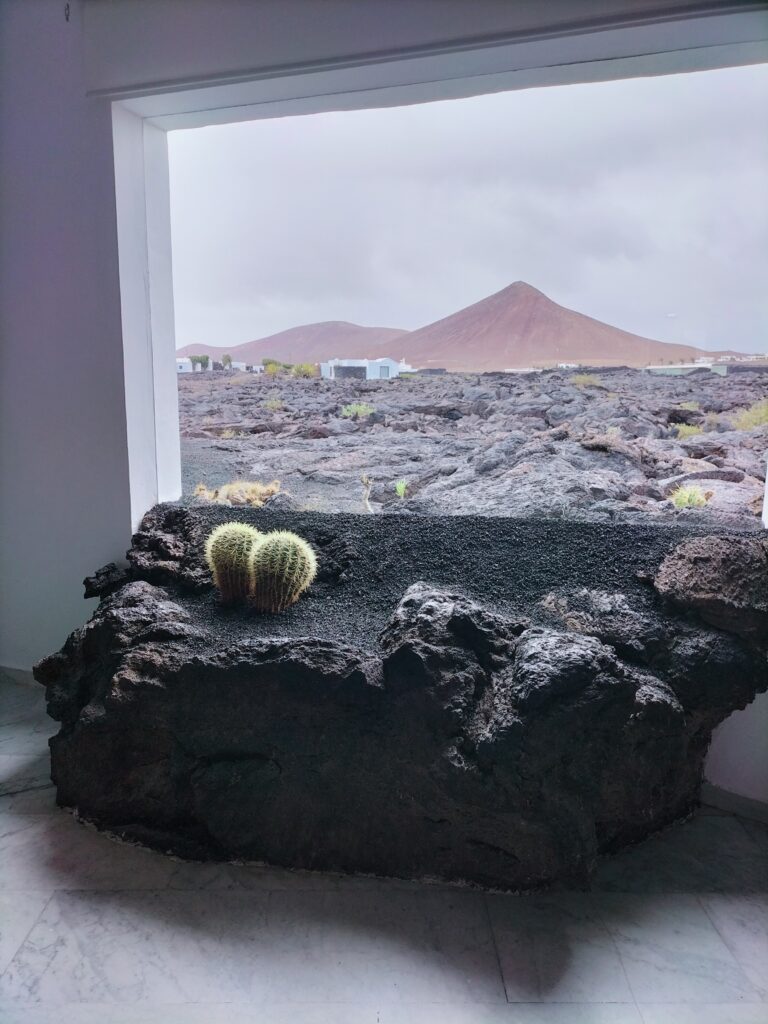 Installation by Cesar Manrique with lava entering his house. In the background a mountain.