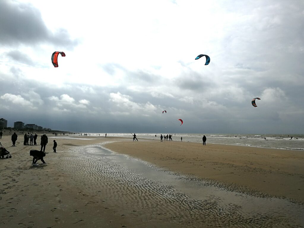 People playing water sports on De Panne beach.