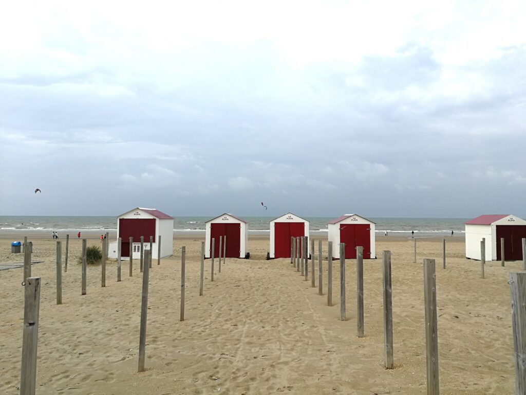 Some cabins with white and red wheels on De Panne beach.