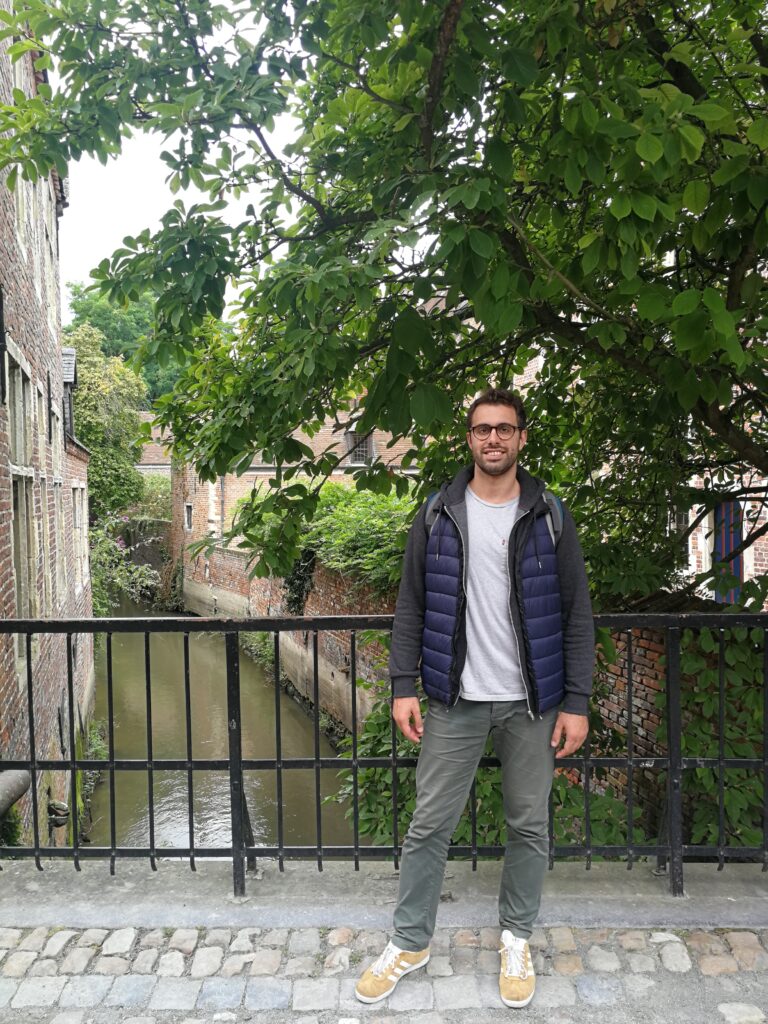 Tiziano in the Great Beguinage neighborhood leaning on a railing. Behind the river.