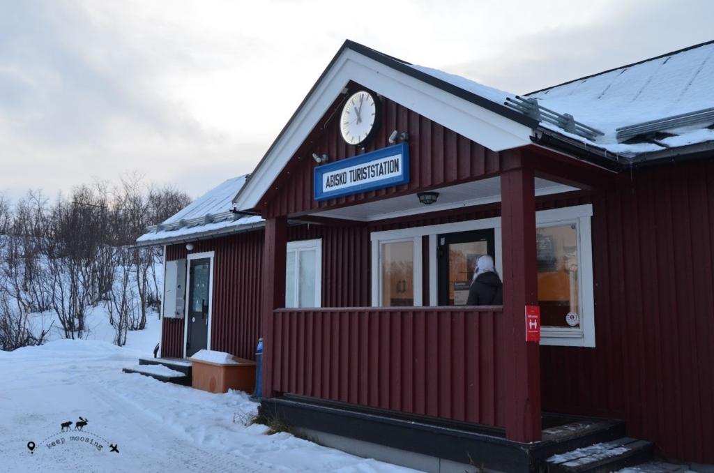 The Abisko train station, typically made of wood and colored red. Immersed in a snowy scenery.