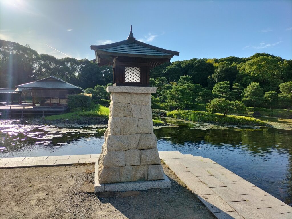 A lamp inside the Nishitori garden park, in the background trees and the lake.