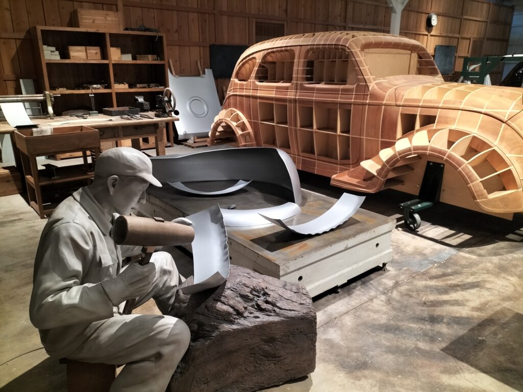 An installation inside the museum with a man who works with car covering materials.