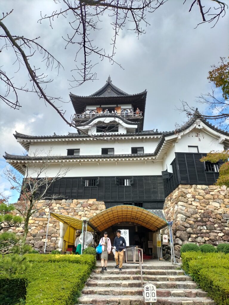 Front view of Inuyama Castle with two Japanese tourists.