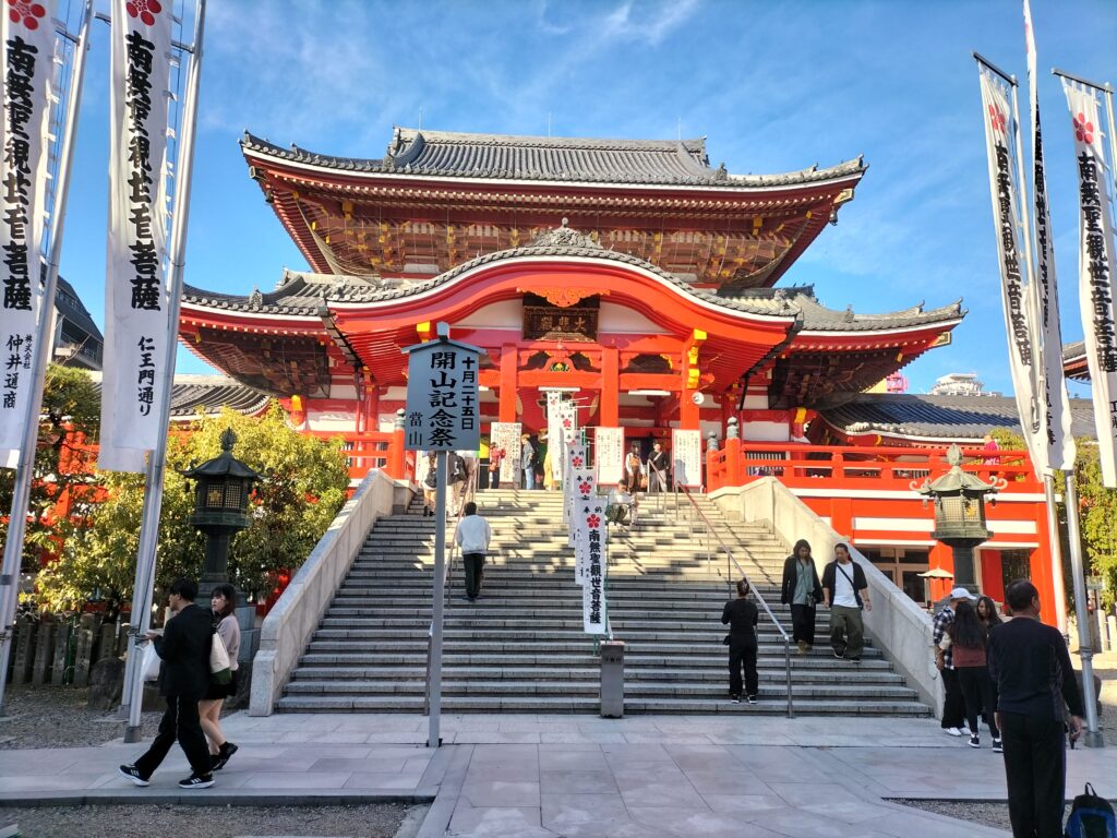 A front view of the Osu Kannon Temple. In the foreground the stairs and tourists.