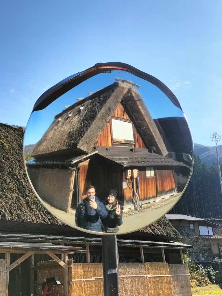 Tiziano and Claudia reflected in the mirror together with a typical house.