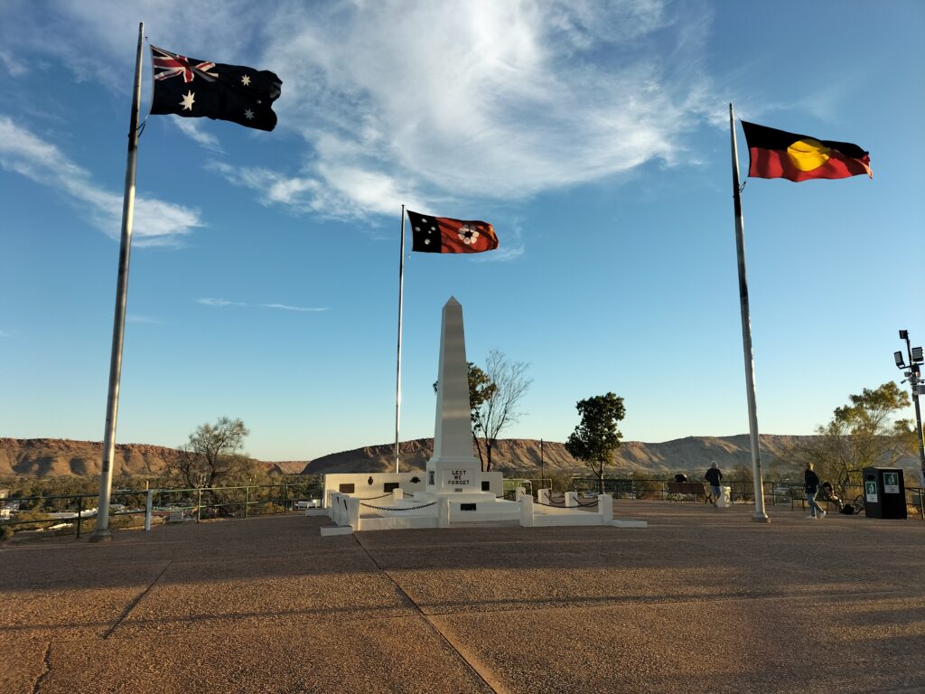 Anzac Hill with 3 flags and mountains in the background.