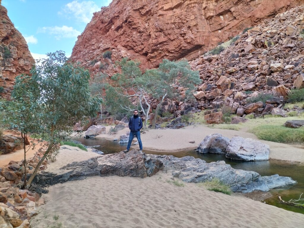 Tiziano at Simpons's Gap with trees and mountain behind.