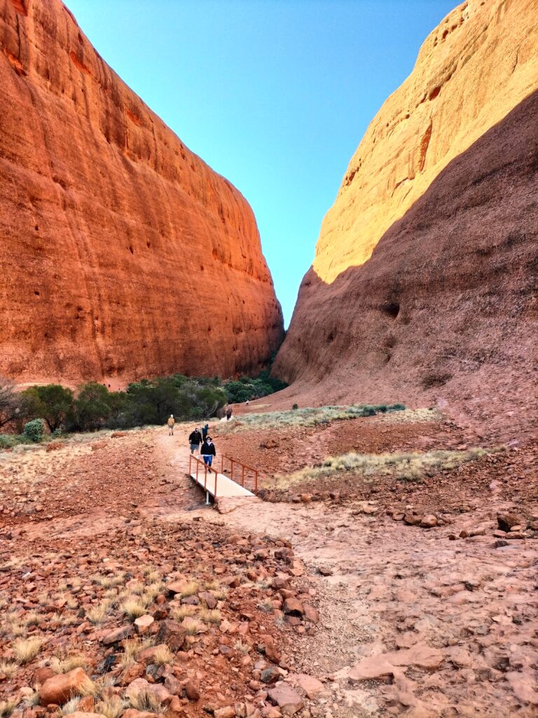 Path to the Olgas with red sand and blue sky.