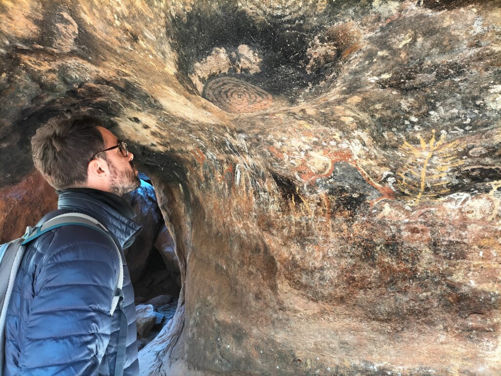 Tiziano looking at the cave paintings on Uluru wall.