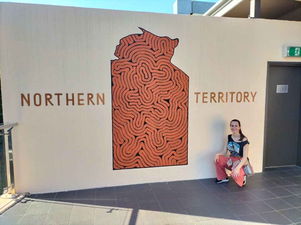 Claudia in front of a wall with written "Northern Territory".