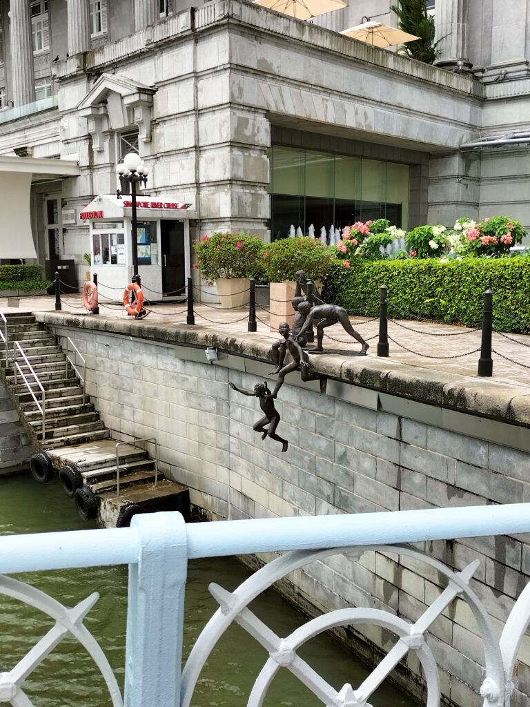 A statue of boys along the river.