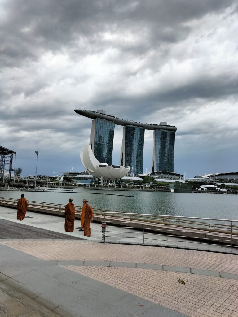 Marina Bay Sands and Museum of Science in the background. In the foreground 4 monks. What to see in Singapore in 3 days