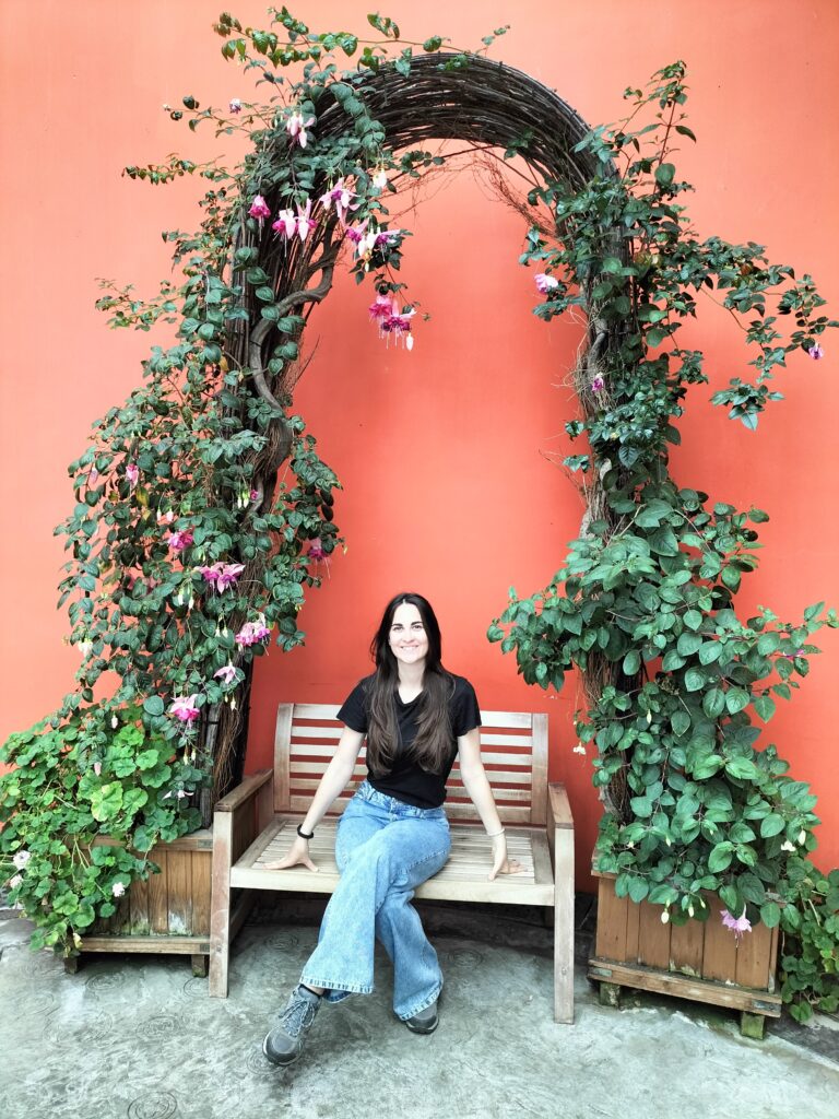 Claudia sit on a bench inside the Cloud forest.