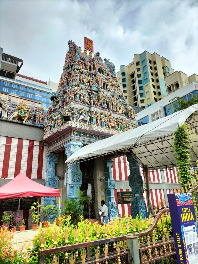 An indian temple in Little India with buildings behind.