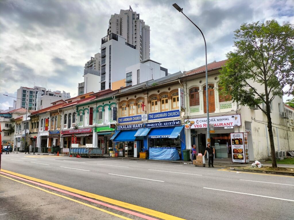 Houses in Little India with skyscrapers in the background.