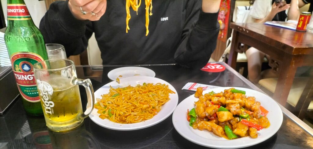 Our food in China Town. Delicacies like noodles and pork with a beer.