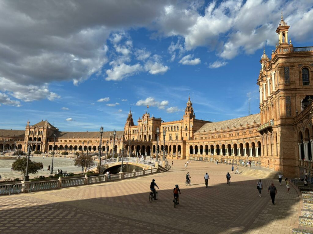 View of the main square of Seville with people on bikes and on foot.