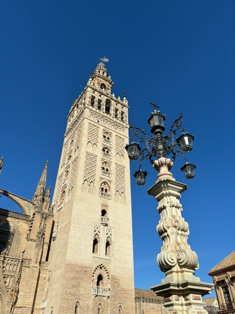 View of the Giralda from the outside with blue sky.