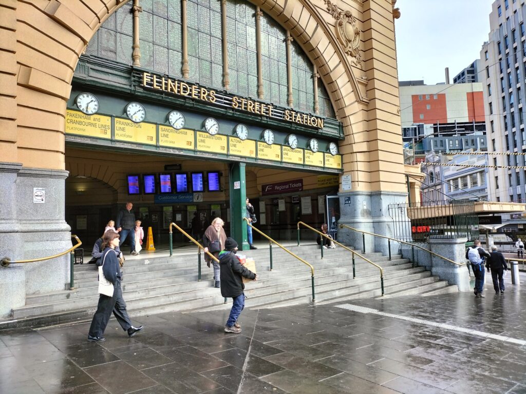 The main entrance of Flinders Street Station with some people.