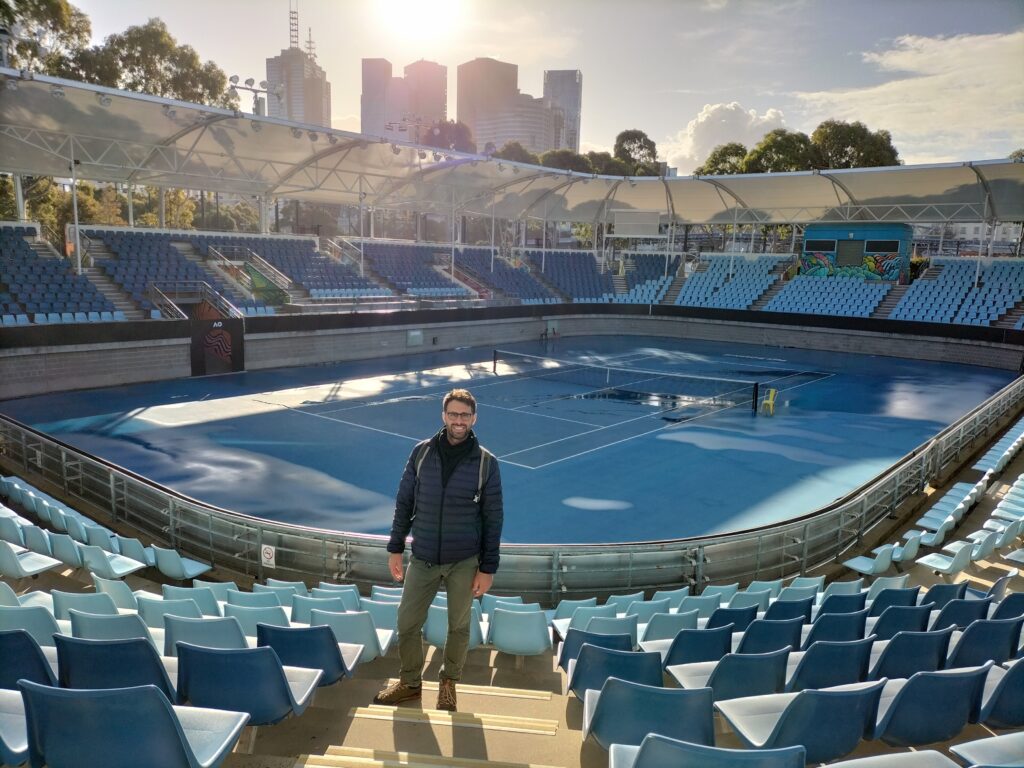 Tiziano inside a tennis court with skyscrapers in the background.